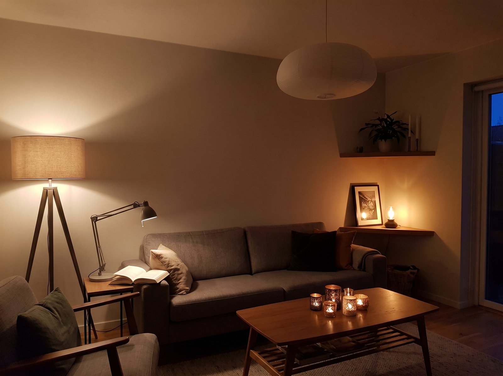 A warm candle holder and soft lamp light creating layered ambience