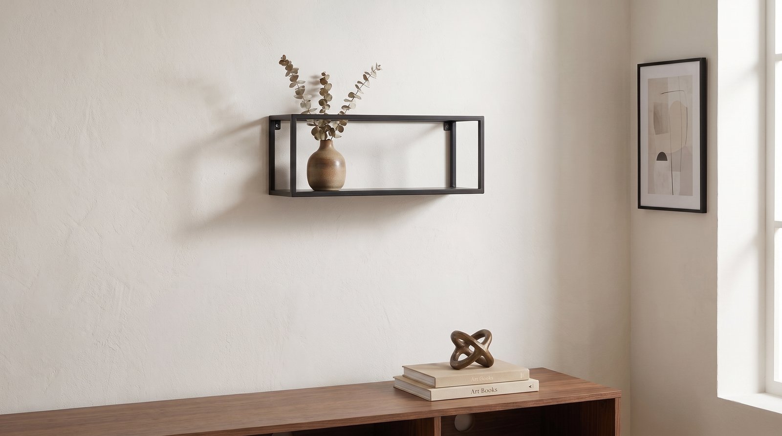 A framed abstract wall art piece in muted earth tones above a console table